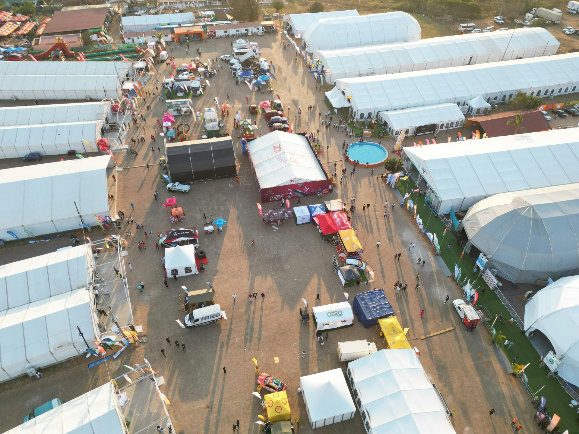 Aerial photograph of a bustling outdoor event with numerous tents, booths, and attendees.