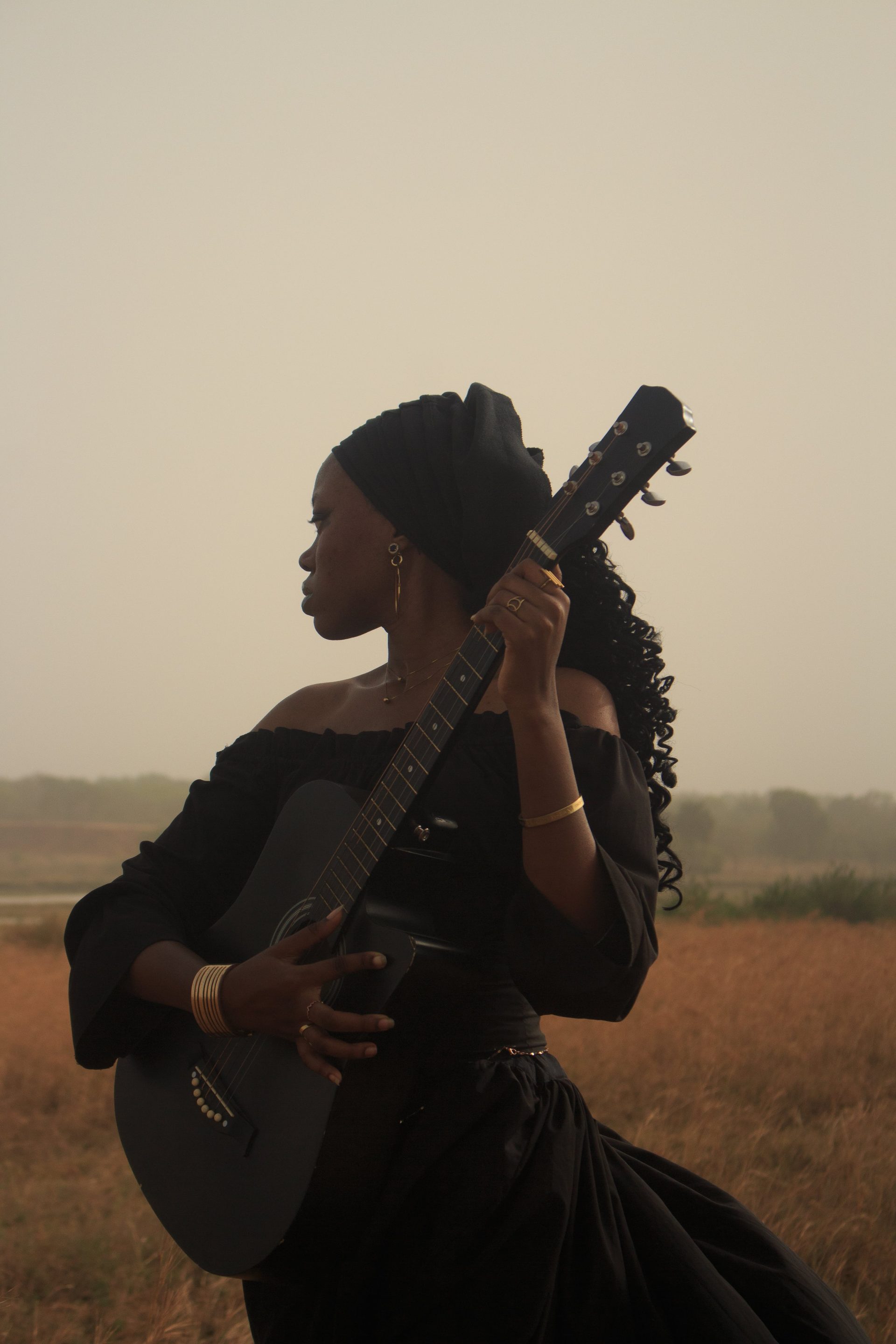 Captivating portrait of a woman with a guitar in a serene outdoor setting, evoking a sense of calm and creativity.