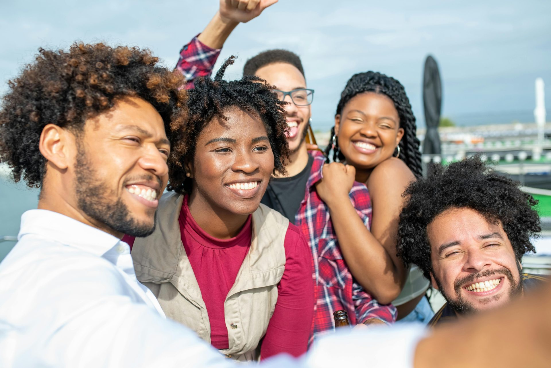 Smiling group of friends taking a selfie outdoors, capturing joyful moments together.